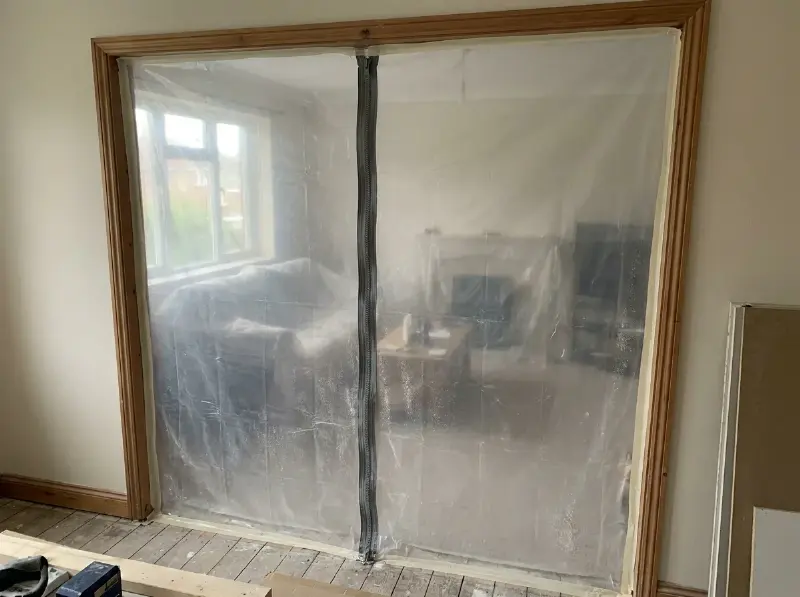 Deuropening afgesloten met een stofzeil met rits tussen twee kamers